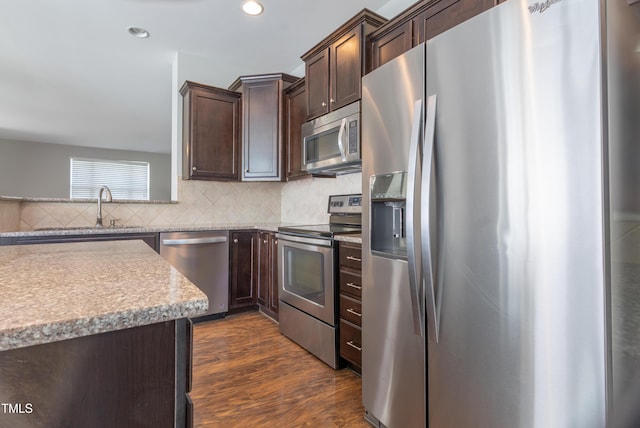 kitchen featuring dark brown cabinetry, appliances with stainless steel finishes, tasteful backsplash, a sink, and recessed lighting