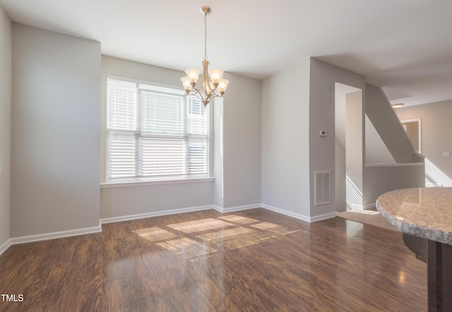 dining space featuring baseboards, a notable chandelier, visible vents, and wood finished floors