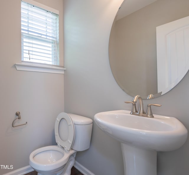 bathroom with baseboards, a sink, and toilet