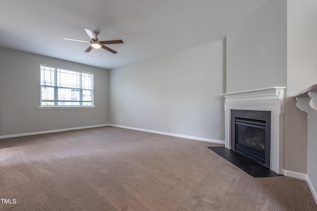unfurnished living room featuring a fireplace with flush hearth, carpet floors, ceiling fan, and baseboards
