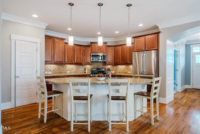 281 N Serenity Hill Cir, Chapel Hill, NC 27516 - kitchen featuring stainless steel appliances, arched walkways, brown cabinetry, tasteful backsplash, and wood finished floors