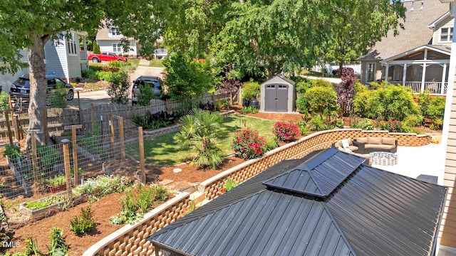 view of yard with fence, a storage shed, an outbuilding, an outdoor living space, and a garden