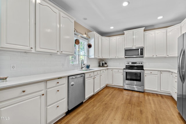 kitchen with a sink, appliances with stainless steel finishes, and white cabinets
