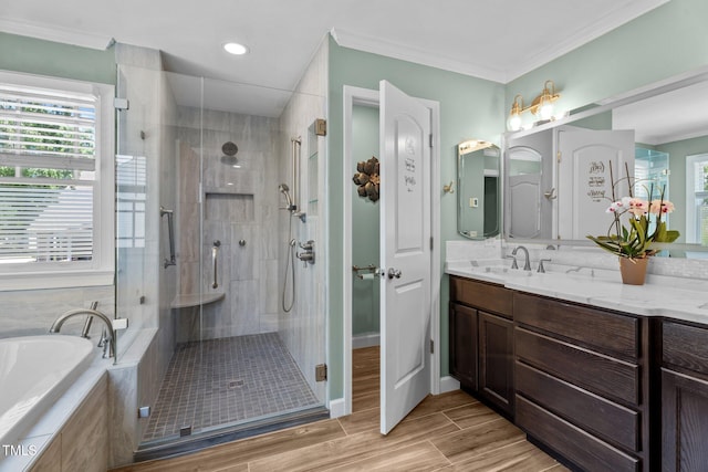 bathroom featuring a garden tub, crown molding, a stall shower, wood finished floors, and vanity