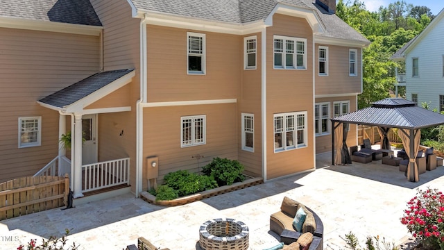 exterior space featuring a gazebo, an outdoor living space, a patio area, and a shingled roof