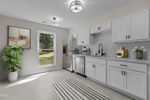 1304 Seaton Rd Unit 24, Durham, NC 27713 - kitchen featuring a sink, visible vents, decorative backsplash, light countertops, and appliances with stainless steel finishes