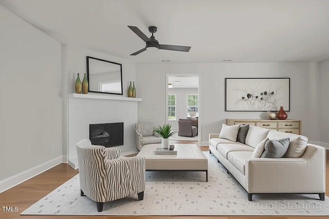 1304 Seaton Rd Unit 24, Durham, NC 27713 - living area featuring wood finished floors, ceiling fan, and a fireplace with raised hearth