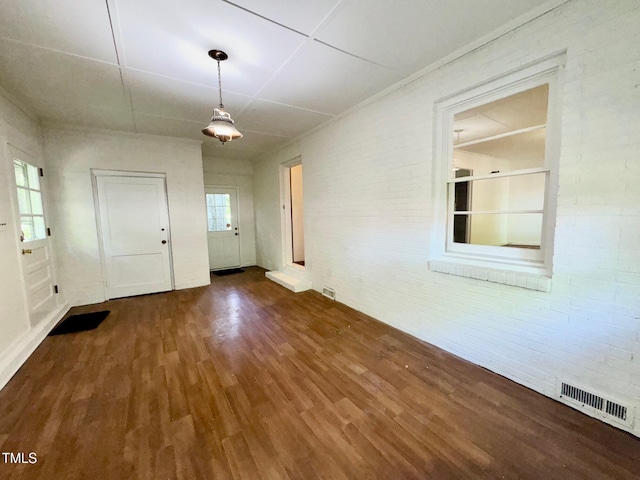1713 S Garnett St, Henderson, NC 27536 - unfurnished dining area with wood finished floors and brick wall