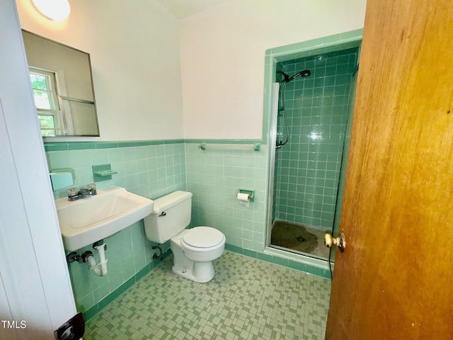 1713 S Garnett St, Henderson, NC 27536 - full bath featuring a stall shower, toilet, a wainscoted wall, tile walls, and a sink