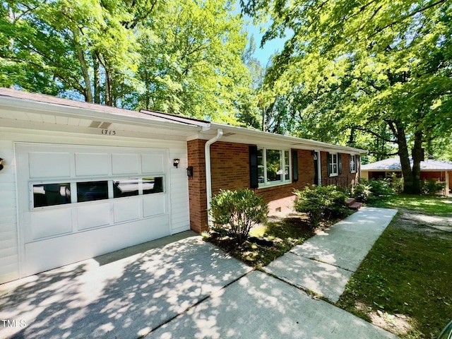 1713 S Garnett St, Henderson, NC 27536 - view of front of home featuring brick siding, a garage, and driveway