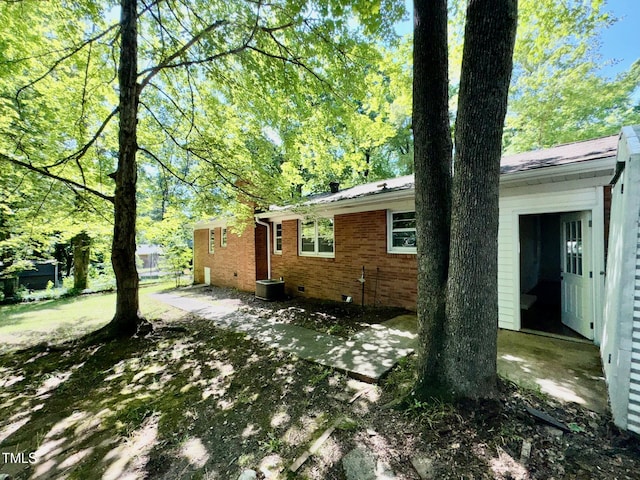 1713 S Garnett St, Henderson, NC 27536 - view of side of property with a patio, brick siding, central air condition unit, and crawl space