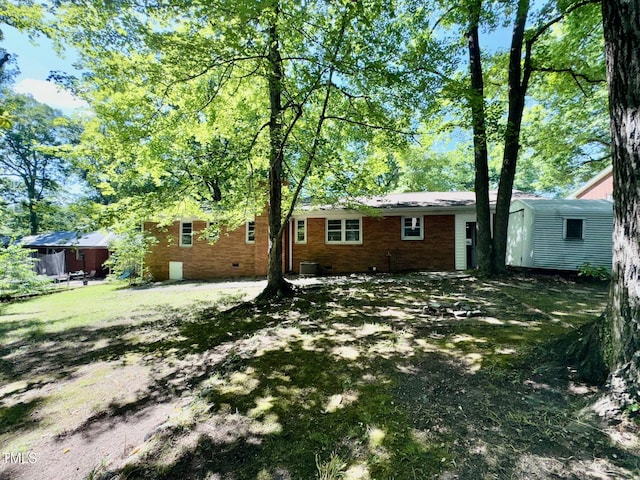 1713 S Garnett St, Henderson, NC 27536 - rear view of house with brick siding, central AC, an outbuilding, and a storage unit