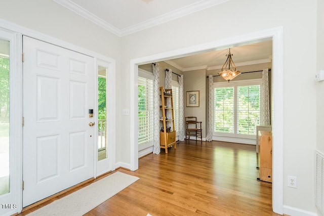 entryway featuring light wood finished floors, baseboards, and crown molding