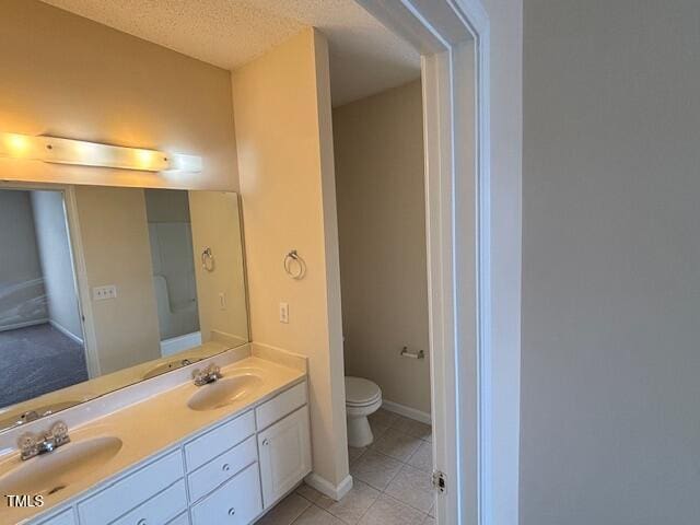 full bath featuring a sink, tile patterned flooring, toilet, and double vanity