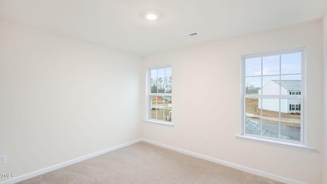 empty room featuring baseboards, carpet flooring, and visible vents