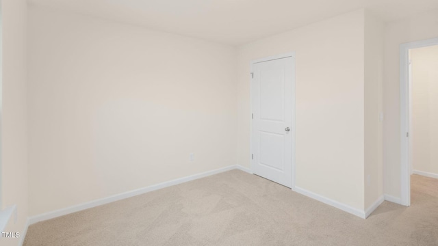 empty room with baseboards and light colored carpet