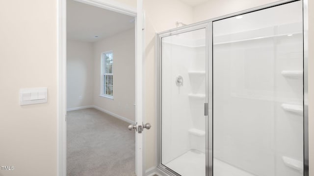 bathroom with baseboards and a shower stall
