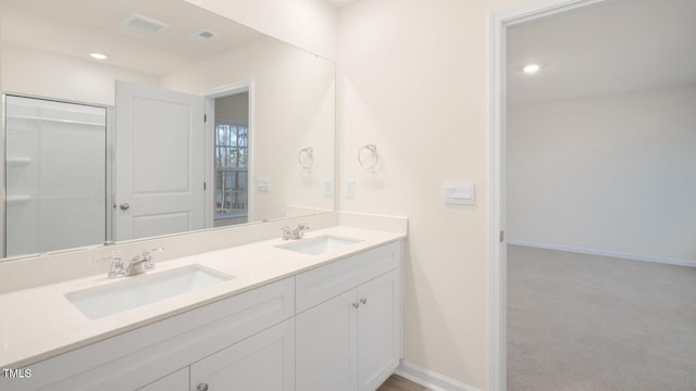 full bath featuring baseboards, a sink, double vanity, and recessed lighting