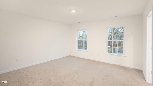 empty room with baseboards and light carpet