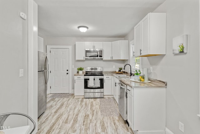 226 S Windsor Dr, Fayetteville, NC 28301 - kitchen featuring a sink, light wood finished floors, light countertops, stainless steel appliances, and white cabinetry