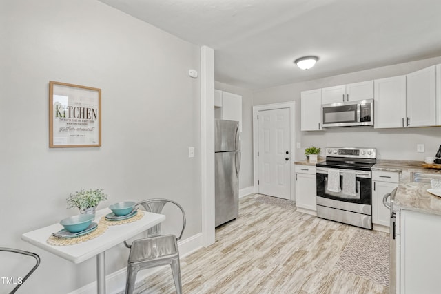226 S Windsor Dr, Fayetteville, NC 28301 - kitchen with light wood-style floors, appliances with stainless steel finishes, baseboards, and white cabinetry