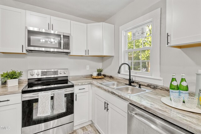 226 S Windsor Dr, Fayetteville, NC 28301 - kitchen with light countertops, white cabinetry, appliances with stainless steel finishes, and a sink