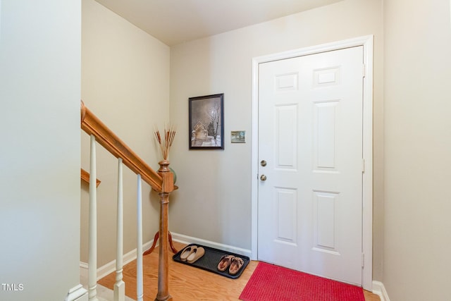 foyer featuring baseboards and wood finished floors