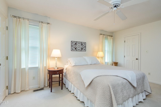 bedroom with baseboards, multiple windows, light carpet, and visible vents
