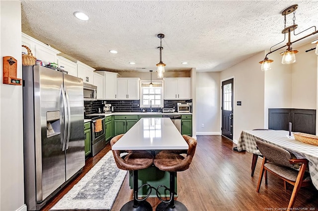 kitchen featuring decorative backsplash, dark wood-style flooring, white cabinets, green cabinetry, and stainless steel appliances