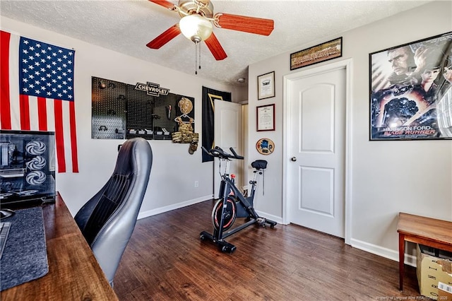 exercise area with a textured ceiling, baseboards, a ceiling fan, and wood finished floors