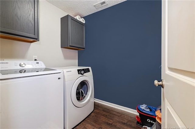 laundry room featuring visible vents, dark wood-style flooring, baseboards, washer and clothes dryer, and cabinet space