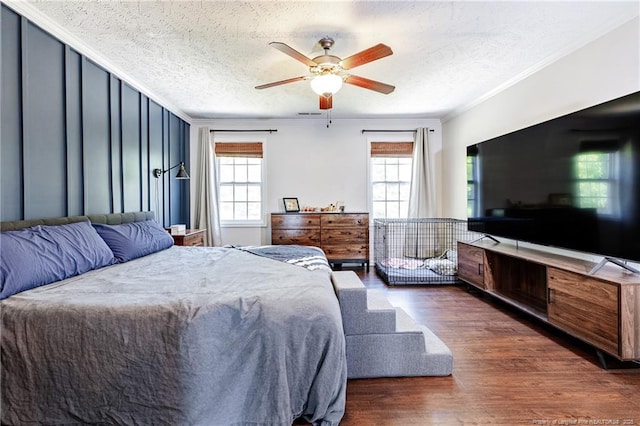 bedroom featuring crown molding, a textured ceiling, ceiling fan, and wood finished floors