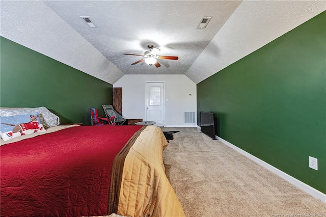 carpeted bedroom with a textured ceiling, visible vents, and lofted ceiling