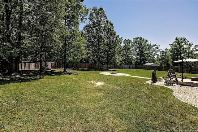 view of yard with a fire pit, a fenced backyard, and a patio area