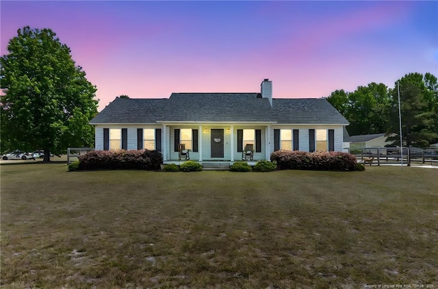 single story home featuring a porch, a front lawn, fence, and a chimney