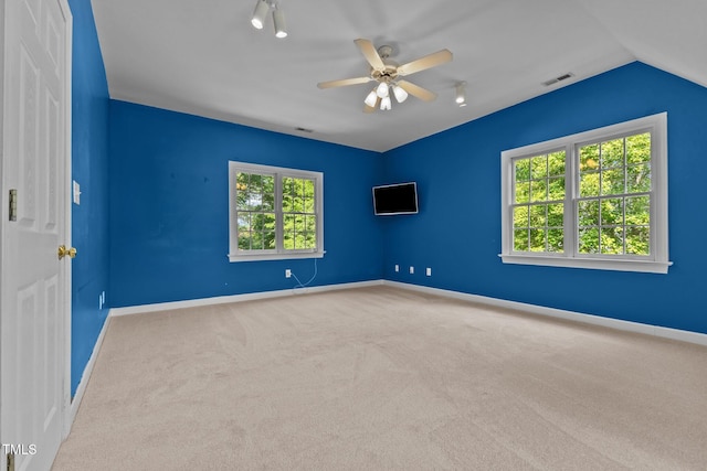 spare room with carpet floors, baseboards, a ceiling fan, and visible vents