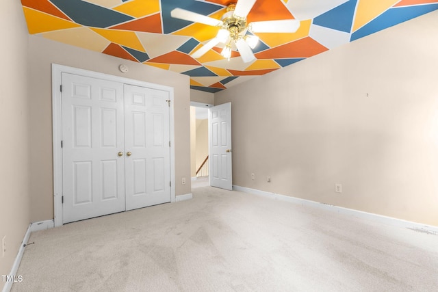 unfurnished bedroom with a closet, carpet flooring, and baseboards