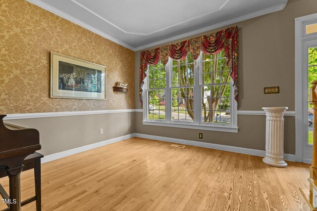 interior space featuring visible vents, ornamental molding, a wealth of natural light, and wood finished floors