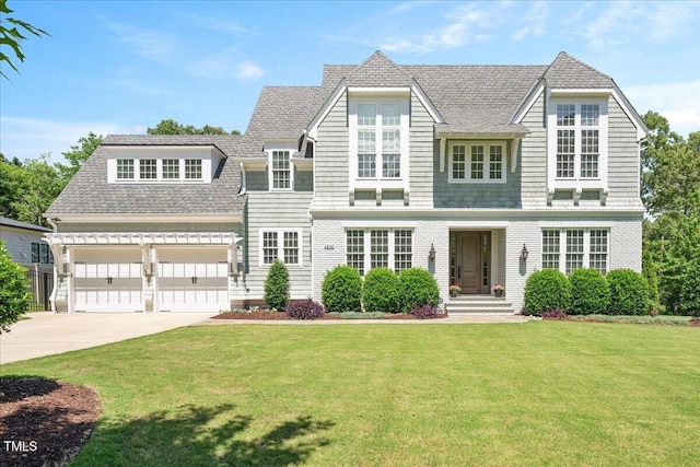 shingle-style home with driveway, a front lawn, and a garage