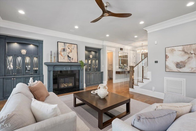 living area featuring crown molding, recessed lighting, stairs, wood finished floors, and ceiling fan