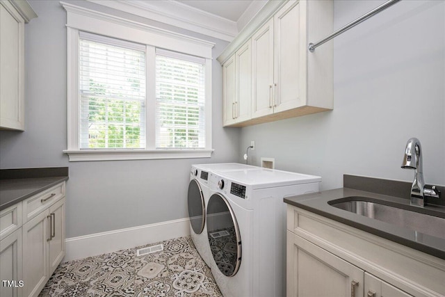 clothes washing area with cabinet space, separate washer and dryer, baseboards, and ornamental molding