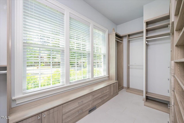 walk in closet with light tile patterned floors
