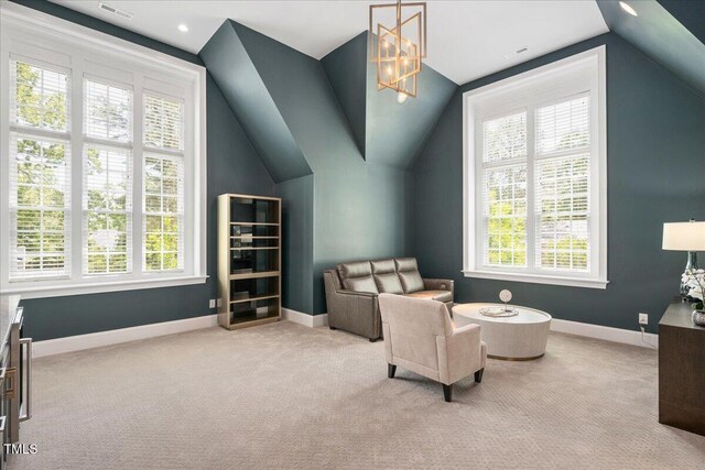 living area featuring healthy amount of natural light, carpet, vaulted ceiling, baseboards, and a chandelier