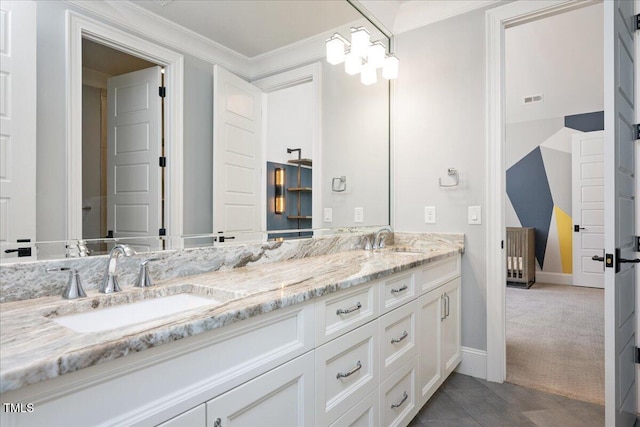 bathroom with crown molding, double vanity, and baseboards