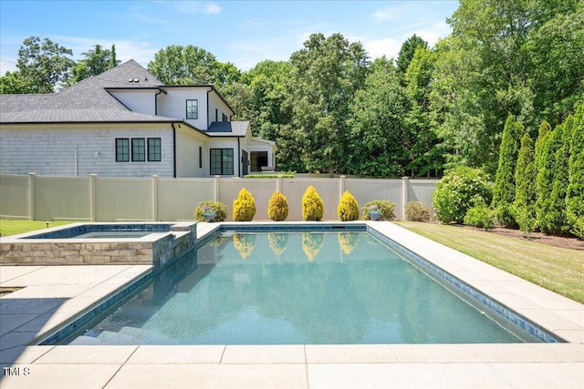 view of pool with fence and a pool with connected hot tub