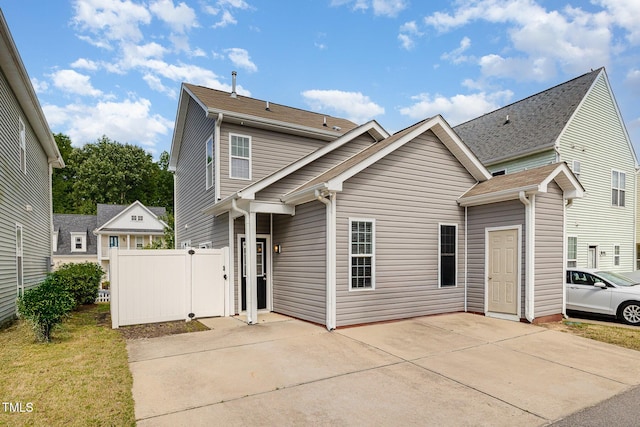 traditional-style home with a patio area, fence, and driveway