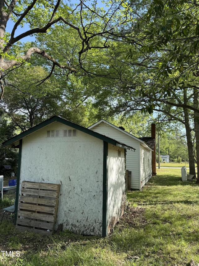 view of property exterior with a lawn, an outdoor structure, and stucco siding