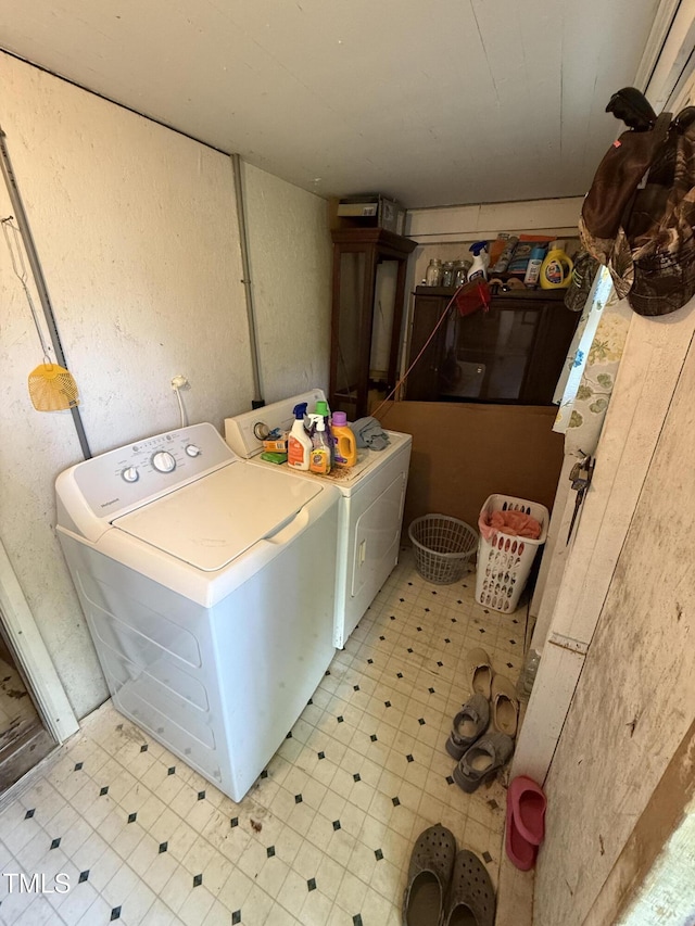 clothes washing area featuring independent washer and dryer and light floors