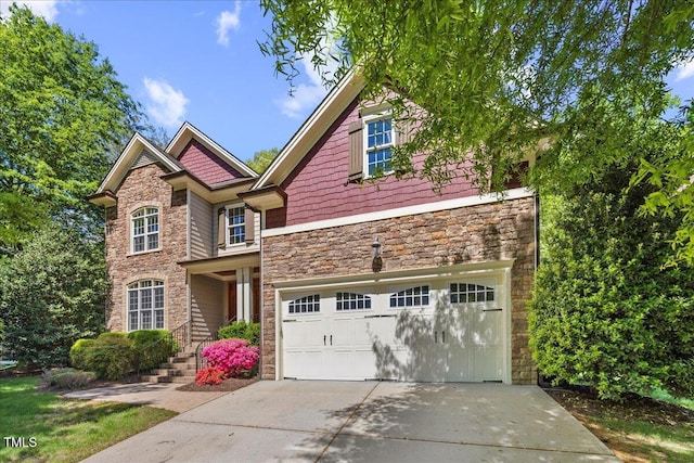 craftsman-style house featuring a garage, stone siding, and concrete driveway