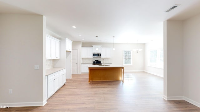 3725 Huntcliff Dr, La Grange, NC 28551 - kitchen featuring visible vents, an inviting chandelier, stainless steel microwave, a sink, and backsplash